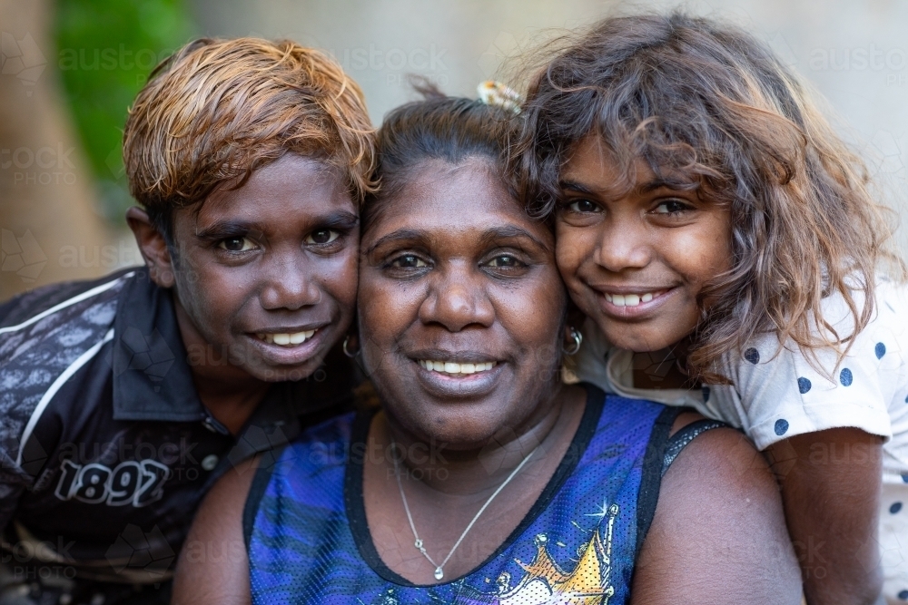 a mother with her two young children posing for a photo - Australian Stock Image