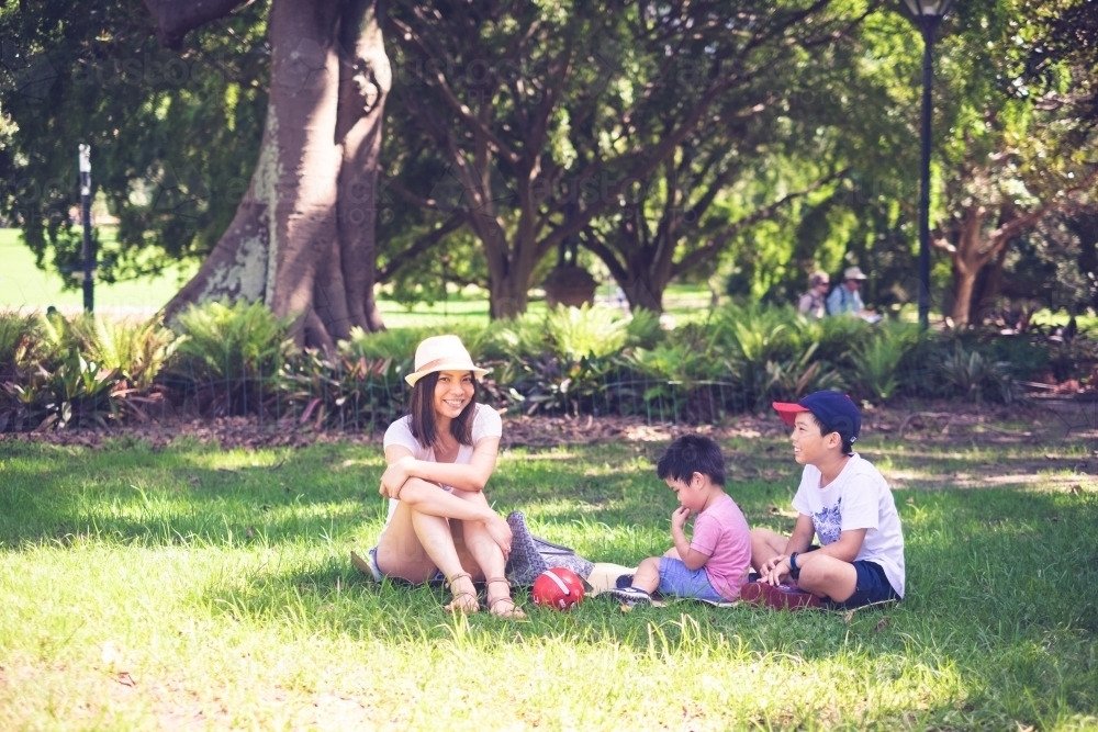 A mum and her kids enjoying a sunny day at the park - Australian Stock Image
