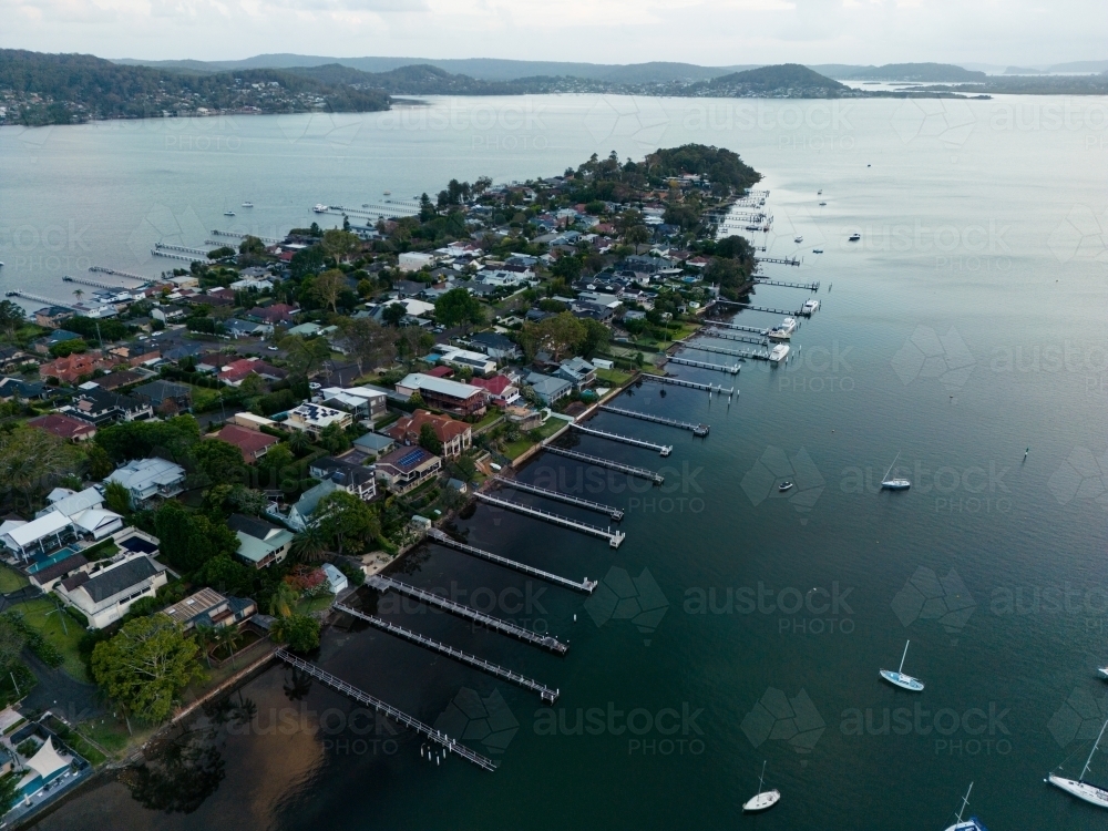 A narrow peninsula surrounded by homes with jetties in Gosford. - Australian Stock Image
