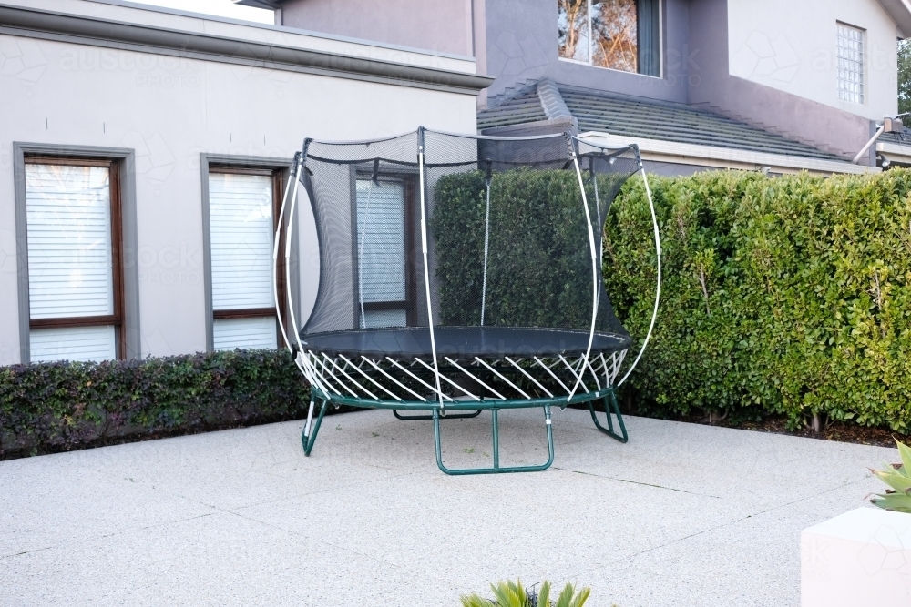 A new trampoline sits in the driveway of a modern home - Australian Stock Image