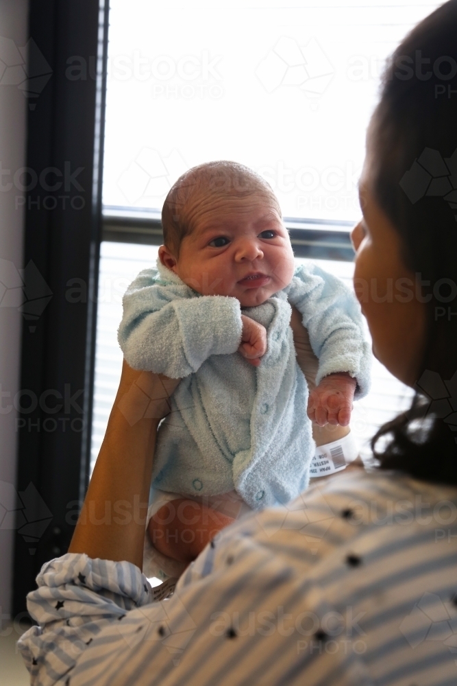 A newborn being held up by his mum - Australian Stock Image