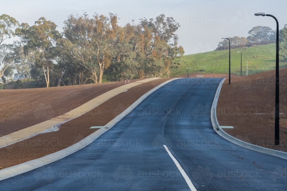 Bituminous Walk Image of A newly laid bitumen road leading over a rise through a new ...