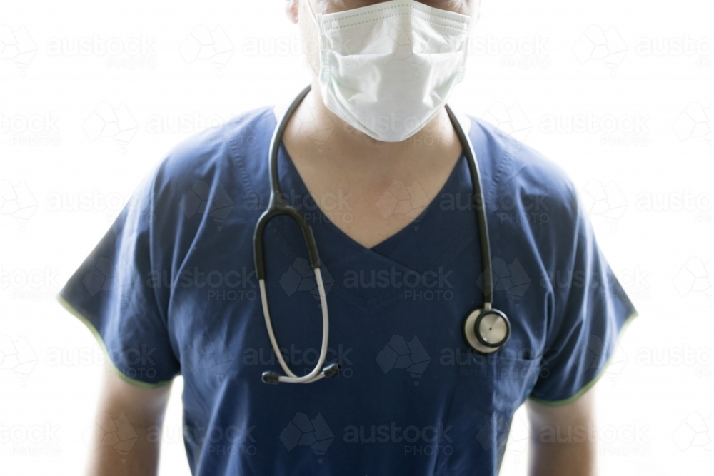 A nurse or doctor wearing scrubs, a facial mask and a stethascope - Australian Stock Image