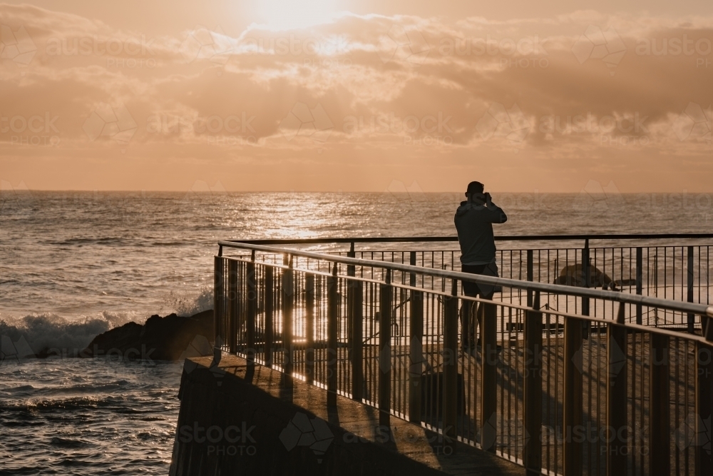 A photographer at the Bronte Ocean Pool (Bronte Baths) at sunrise - Australian Stock Image