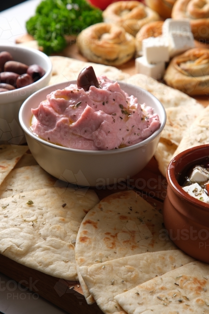 A plate of pita bread with dips and side dishes - Australian Stock Image