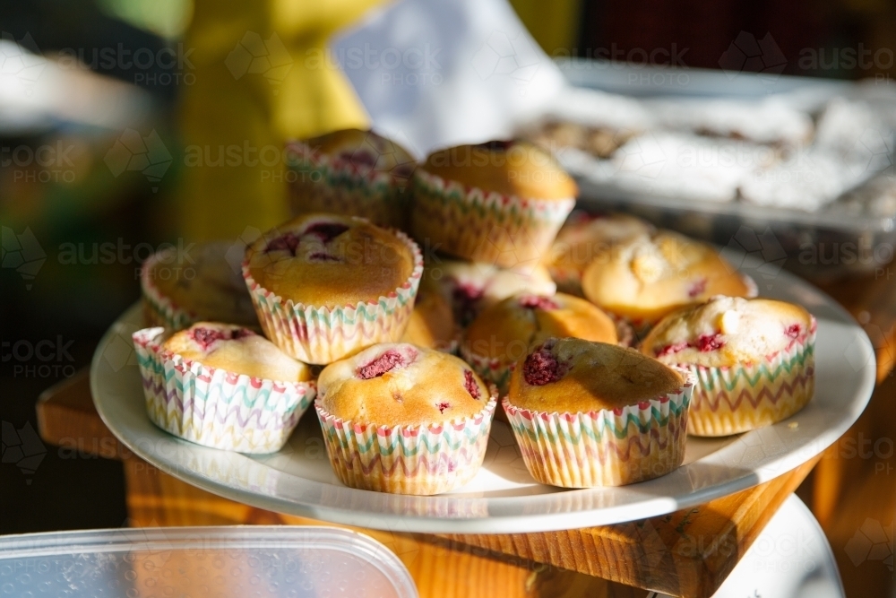 A plate of strawberry muffins on a wooden table - Australian Stock Image