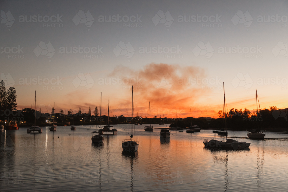 A quiet evening on the Clarence River at Yamba with sugar cane burning smoke in the distance - Australian Stock Image