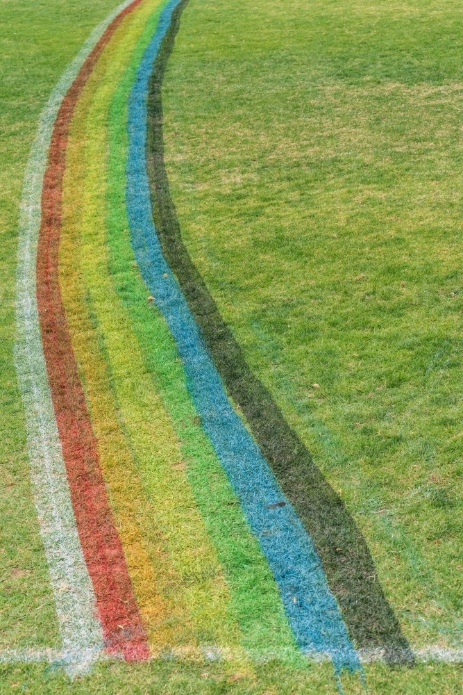 A rainbow arc painted on a grassy sports oval - Australian Stock Image