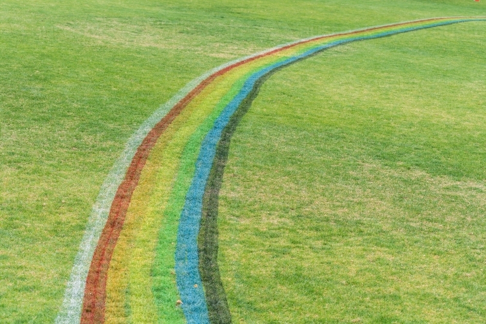 A rainbow arc painted on a grassy sports oval - Australian Stock Image