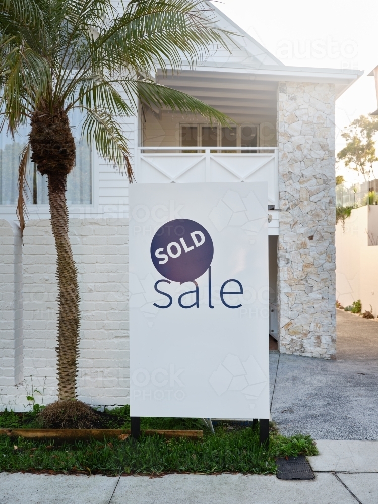 a real estate sign placed outside the house on sale - Australian Stock Image