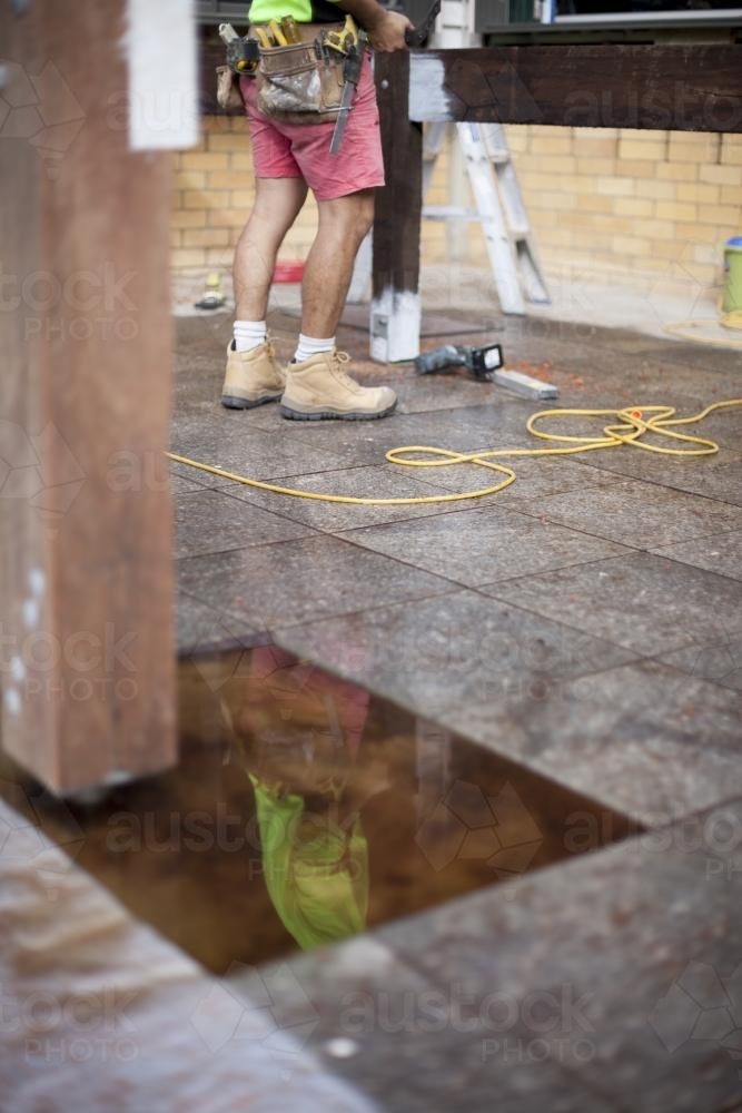 A reflection of a tradesman working on home renovations. - Australian Stock Image