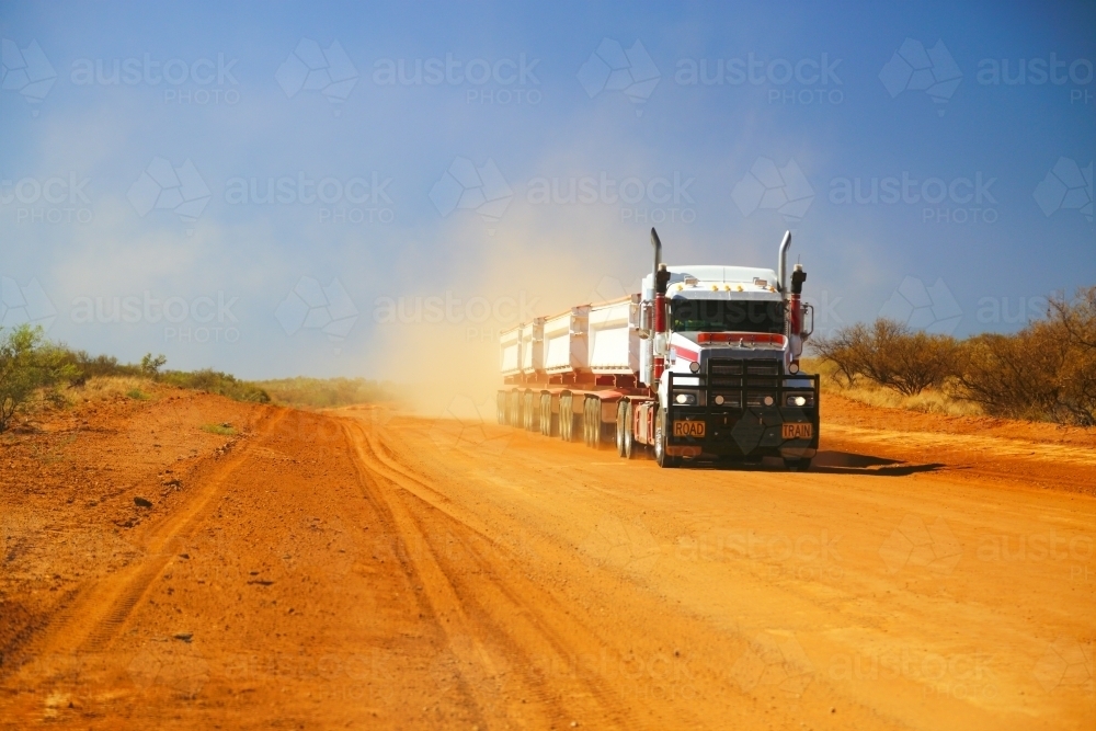 A road train on a dusty road in the Pilbara Region of Western Australia - Australian Stock Image