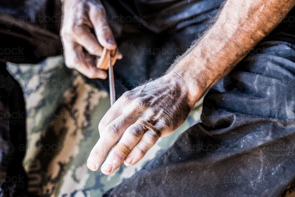 A rock climber prepares by taping his hands - Australian Stock Image