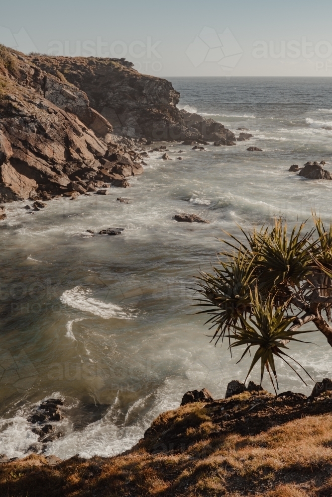 A rocky beach scene just after sunrise near Flynns Beach, Port Macquarie. - Australian Stock Image