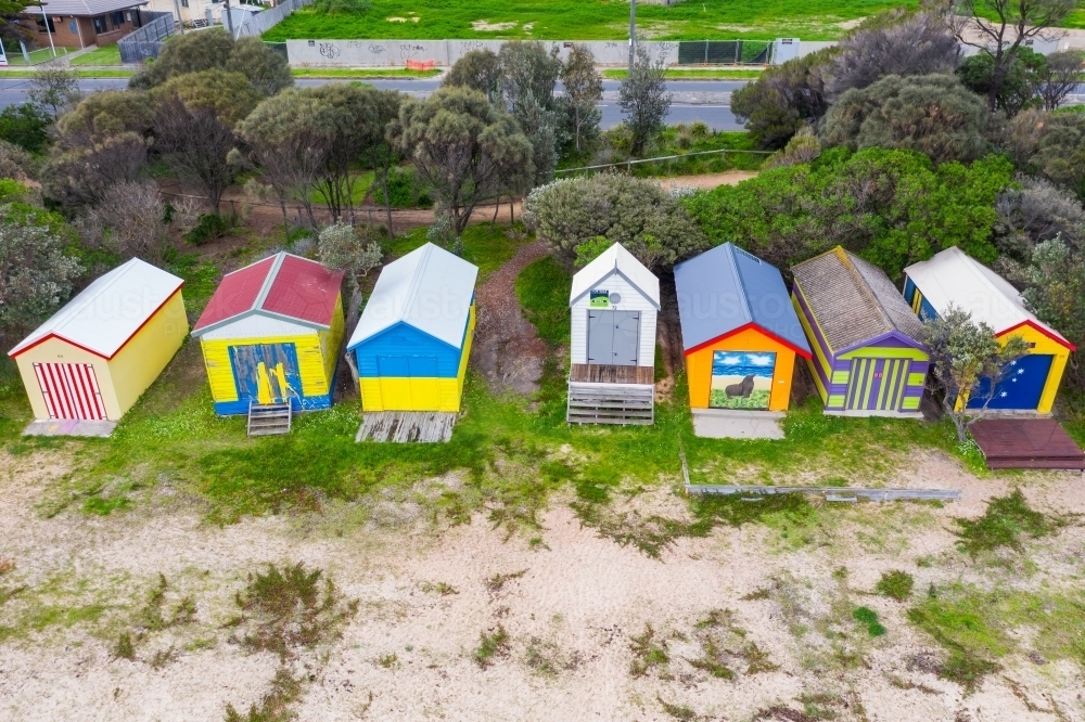 A row of colorful bathing boxes along a bay side beach - Australian Stock Image