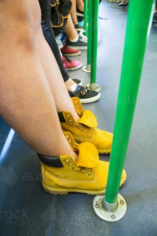 A row of feet on a tram - Australian Stock Image
