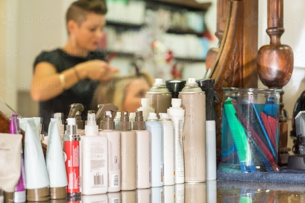 A row of hair care products in front of a mirror in a salon - Australian Stock Image