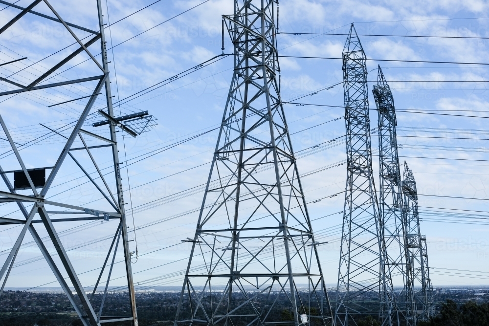 A row of power line towers stretching across the landscape - Australian Stock Image