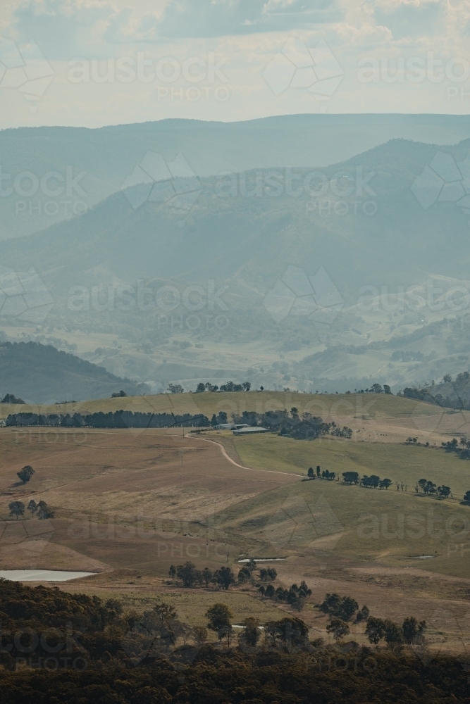 A rural homestead in the valley surrounded by mountains as seen from Blackheath Lookout - Australian Stock Image