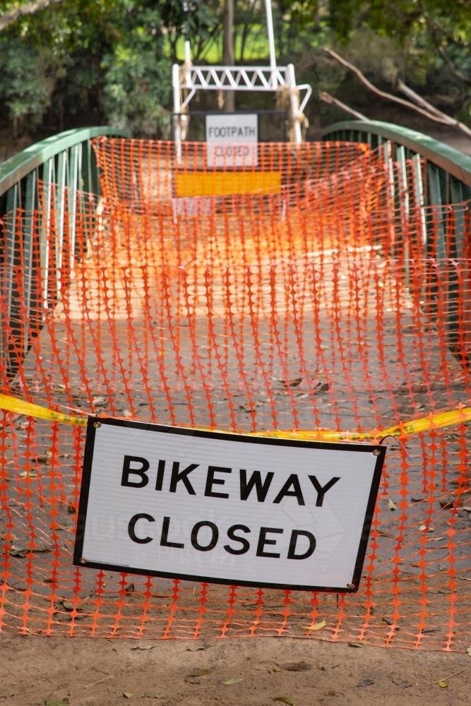A safety barrier blocks a bridge crossing along a suburban bikeway after a flood event - Australian Stock Image
