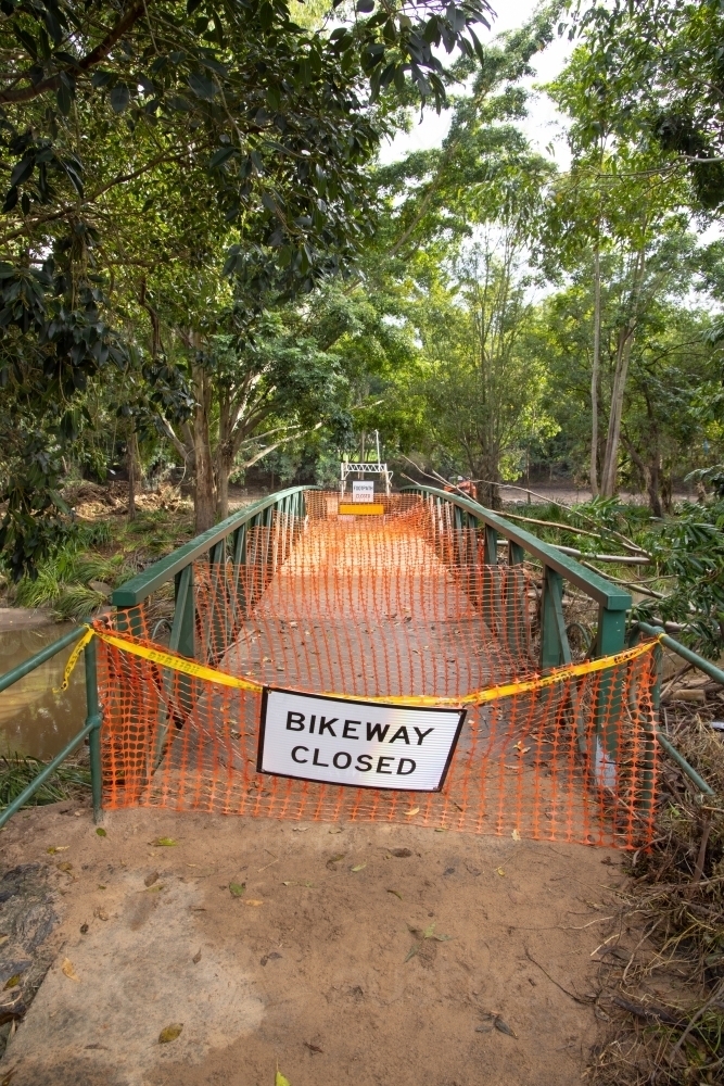 A safety barrier blocks a bridge crossing along a suburban bikeway after a flood event - Australian Stock Image