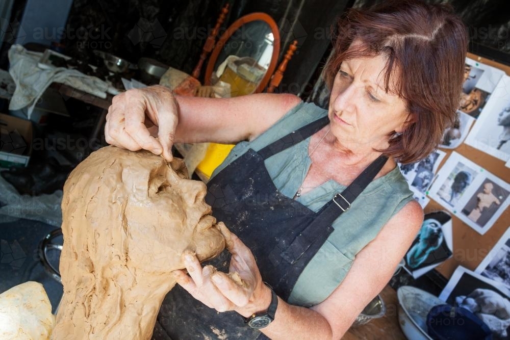 A sculptor working on a clay bust - Australian Stock Image