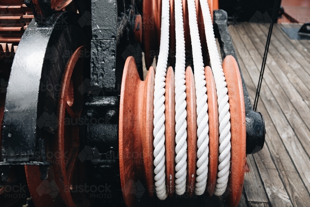 A series of white ropes wound around a large, red wheel or pulley at Old Whaling Station - Australian Stock Image