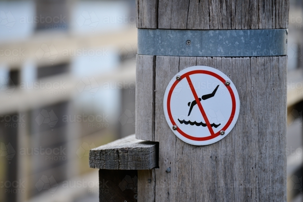 A sign post advising people not to dive off the jetty - Australian Stock Image