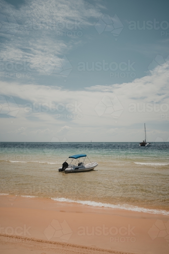 A small boat in the clear blue water near Tangalooma - Australian Stock Image