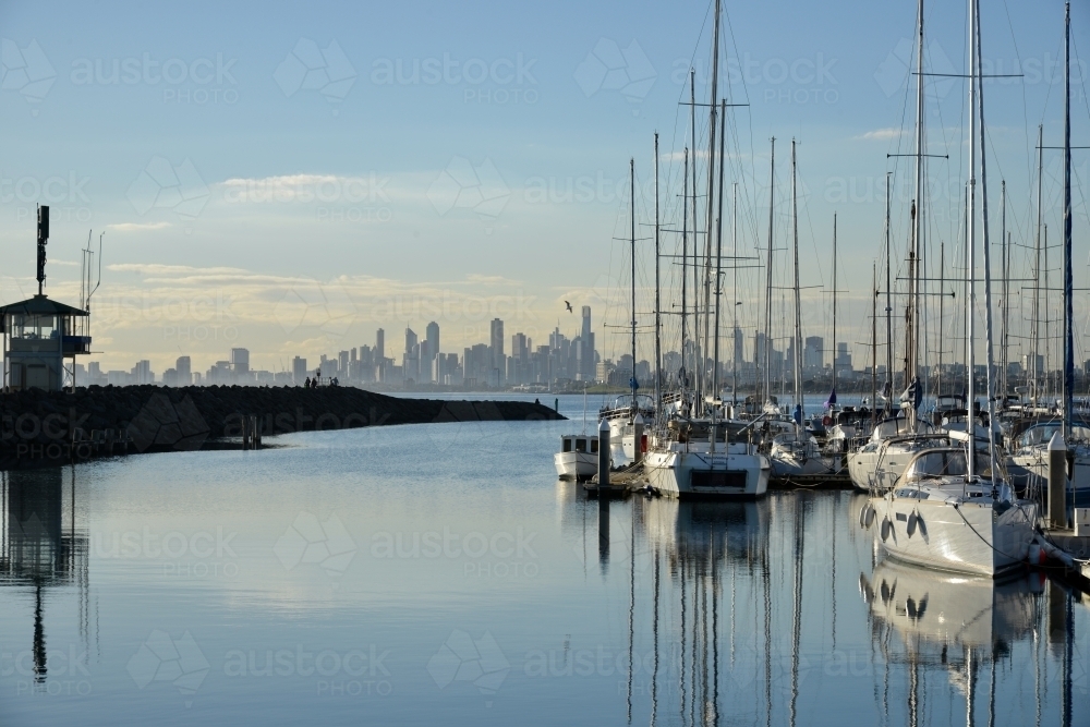 A small harbor full of yachts with the city skyline in the background - Australian Stock Image
