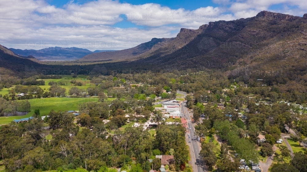 A small regional town in a fertile valley with tree covered mountains each side - Australian Stock Image