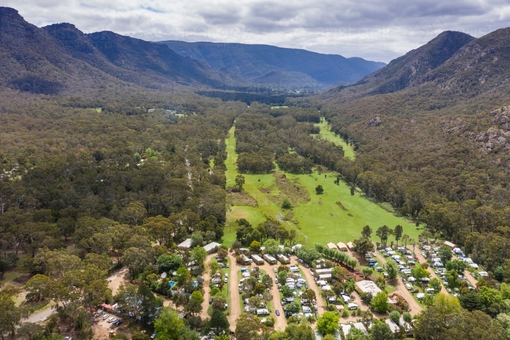 A small regional town in a fertile valley with tree covered mountains each side - Australian Stock Image