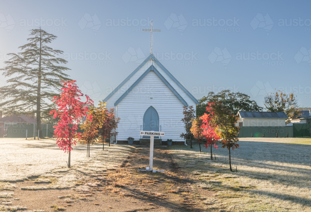 Image of A small white church under a blue sky on an autumn morning ...