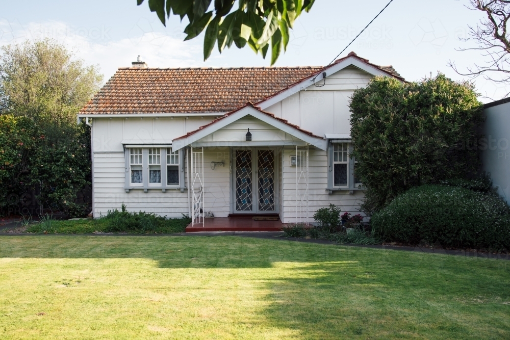 Image of A small, white, old weatherboard house Austockphoto