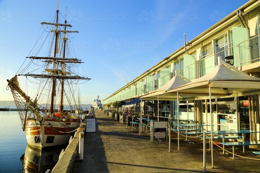 A square rigger docked in front of cafés at Elizabeth Street Pier in Hobart. - Australian Stock Image