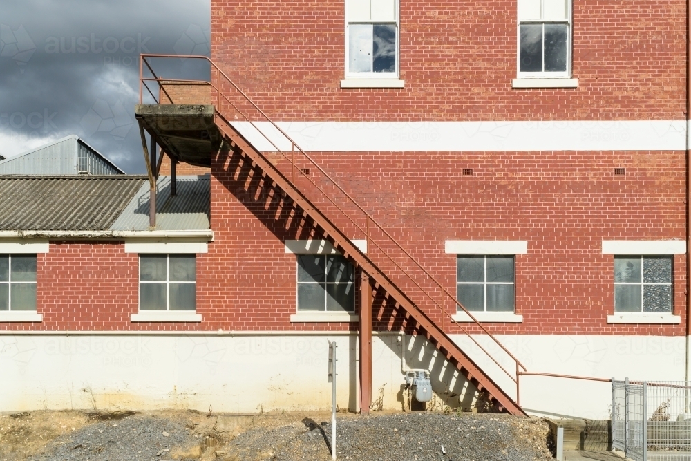 A staircase on the outside of a brick factory wall - Australian Stock Image