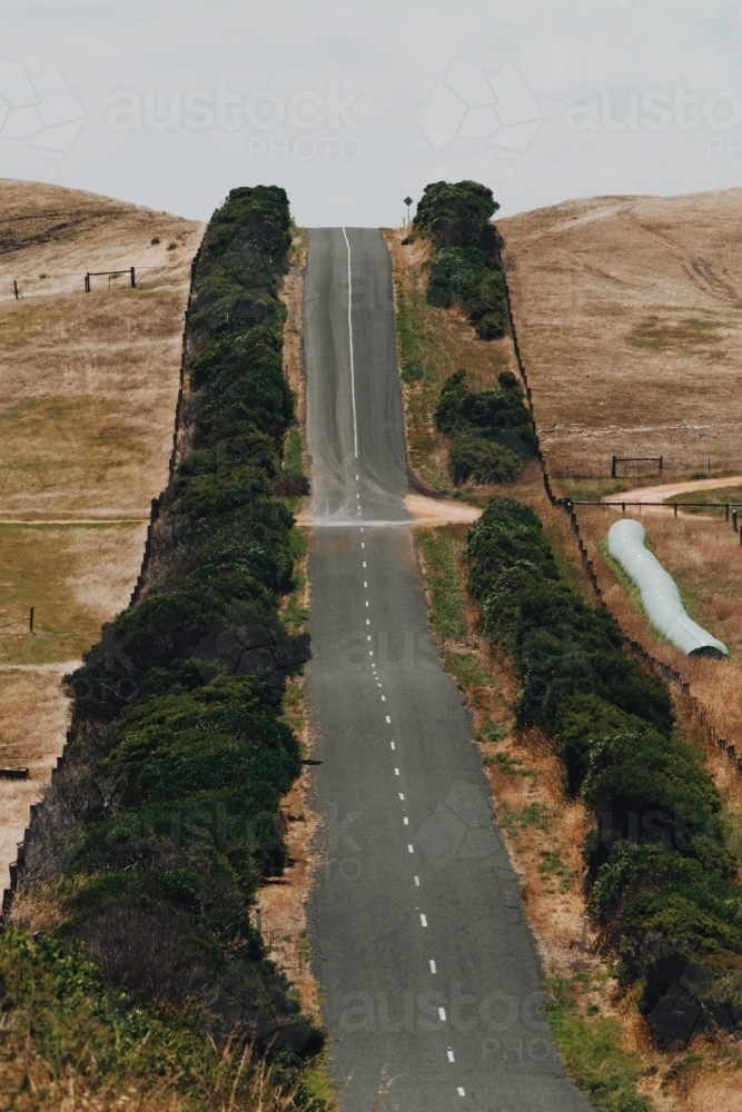 A steep road between farming land - Australian Stock Image