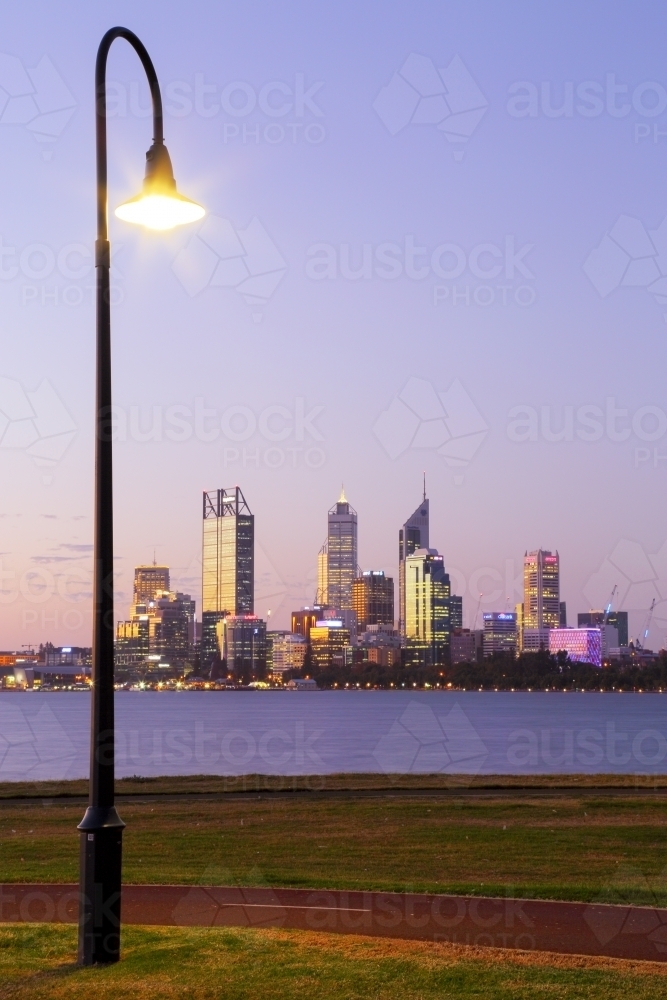 A street light illuminating an exercise track in front of Perth city and the Swan River. - Australian Stock Image