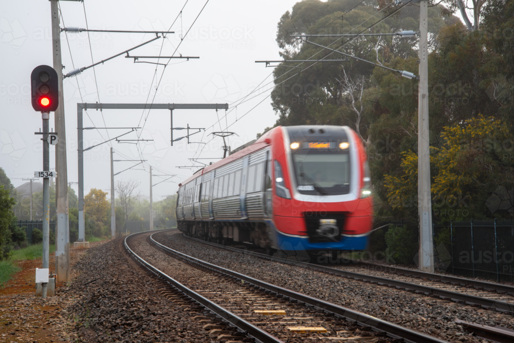 A suburban train on the tracks at Brighton, Adelaide on a foggy day - Australian Stock Image