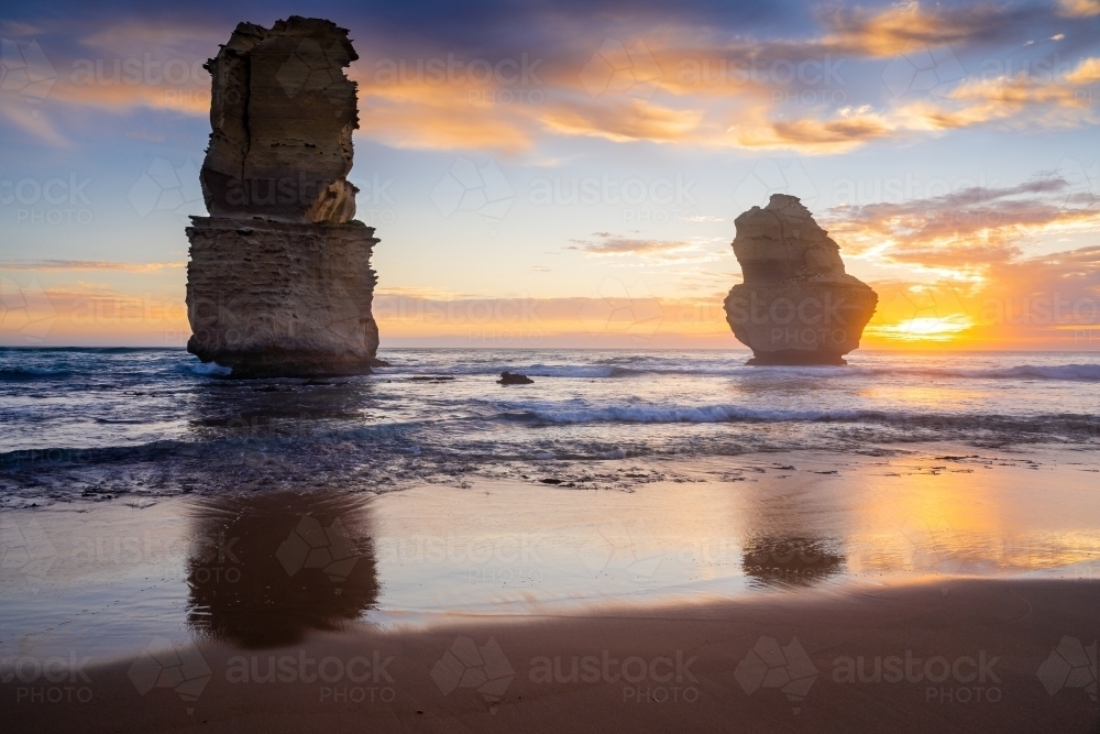 A sunset sky over tall sea stacks rising out of the ocean - Australian Stock Image