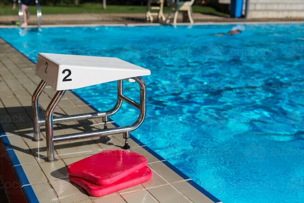 A swimming block with the number 2 and red kickboards at a swimming pool - Australian Stock Image