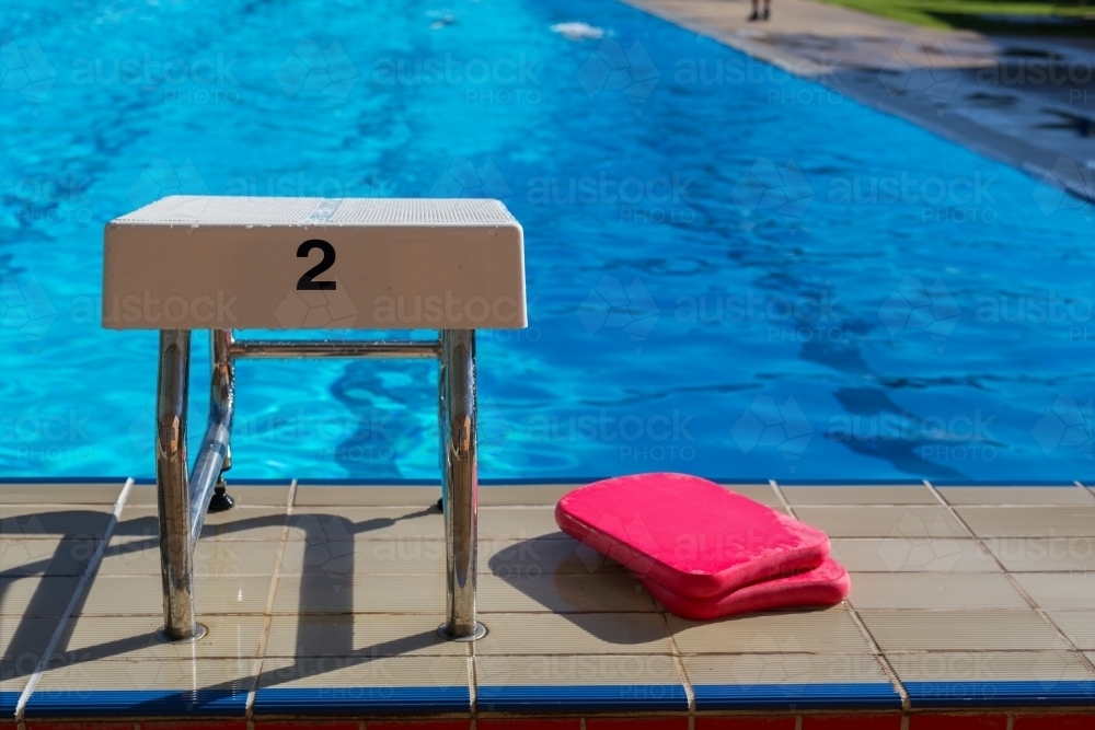 A swimming block with the number 2 and red kickboards at a swimming pool - Australian Stock Image