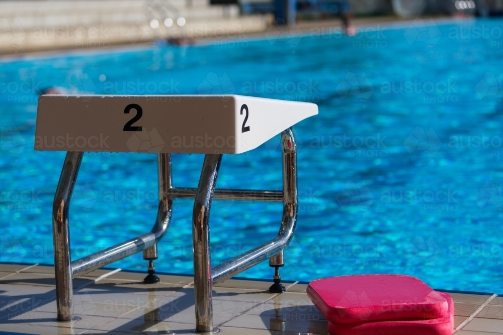 A swimming block with the number 2 and red kickboards at a swimming pool - Australian Stock Image