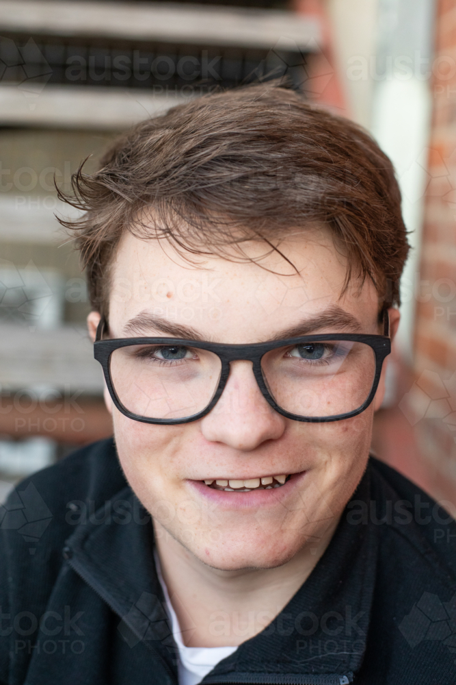 A teenage boy with black glasses smiling - Australian Stock Image