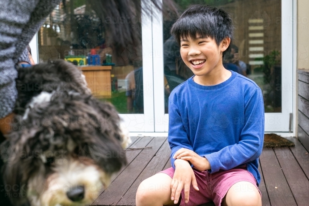 a thrilled boy, and a shaggy dog being carried away - Australian Stock Image