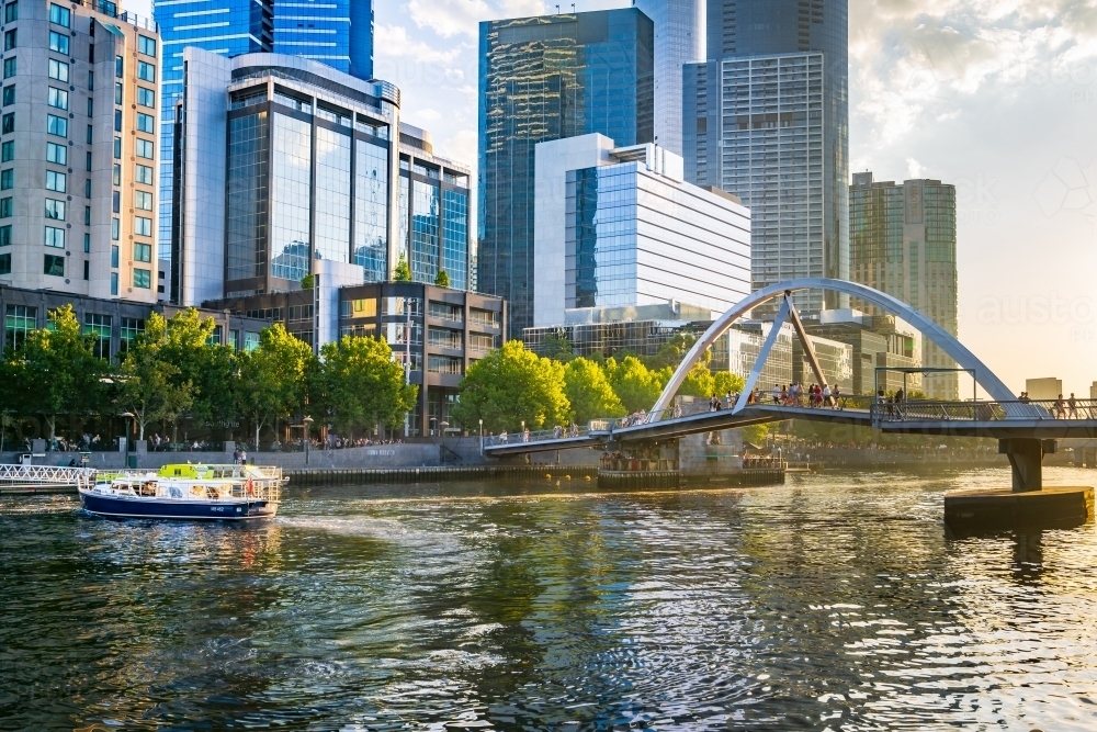 A tourist boat on inner city river with high rise buildings along its banks - Australian Stock Image