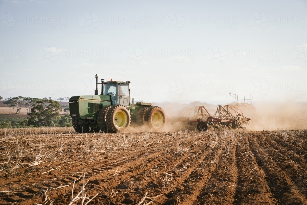 A tractor and seeder dry seeding wheat in the Avon Valley region of Western Australia - Australian Stock Image