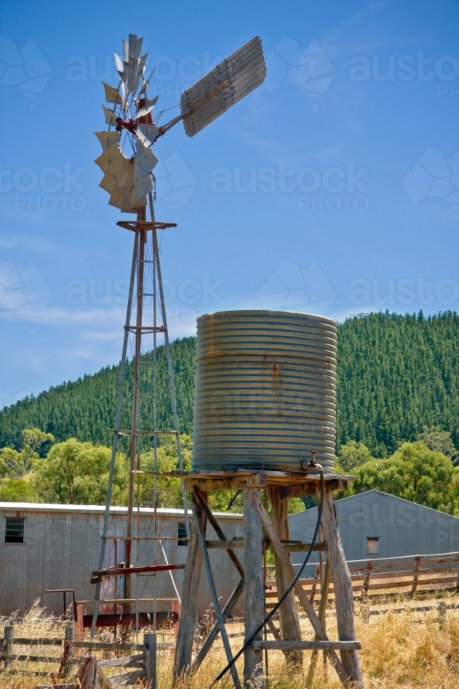 A water tank and windmill standing near farm sheds - Australian Stock Image