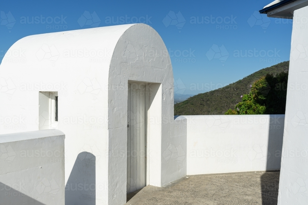 a white curved architectural structure with an open doorway leading to the balcony - Australian Stock Image