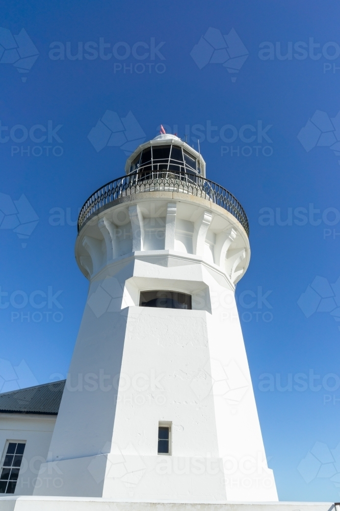a white lighthouse with small windows under a clear blue sky - Australian Stock Image
